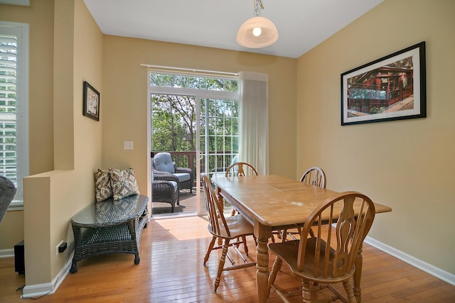 dining space with hardwood / wood-style floors and baseboards