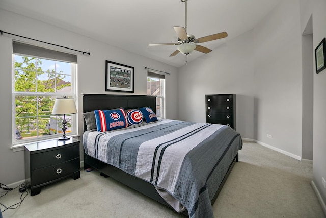 bedroom featuring baseboards, light colored carpet, vaulted ceiling, and ceiling fan