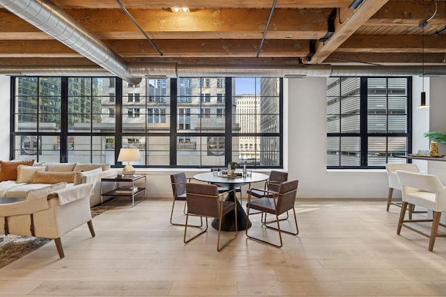 223 W Lake St Unit 3N, Chicago, IL 60606 - dining area with beamed ceiling, light wood finished floors, a wall of windows, and wood ceiling