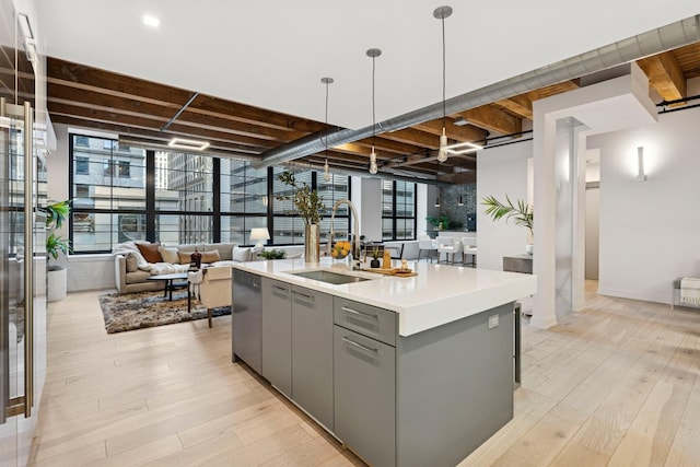 223 W Lake St Unit 3N, Chicago, IL 60606 - kitchen featuring gray cabinetry, a sink, open floor plan, a center island with sink, and light wood-style flooring