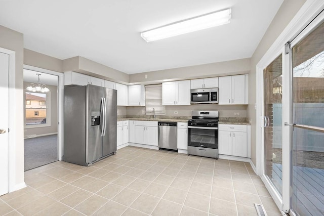 15252 Larkspur Ln, Orland Park, IL 60462 - kitchen featuring appliances with stainless steel finishes, a chandelier, light tile patterned flooring, white cabinetry, and light stone counters