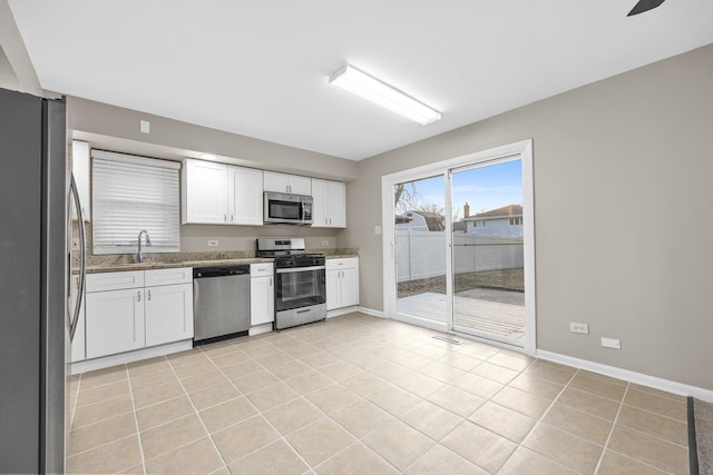 15252 Larkspur Ln, Orland Park, IL 60462 - kitchen with appliances with stainless steel finishes, white cabinetry, a sink, baseboards, and stone counters