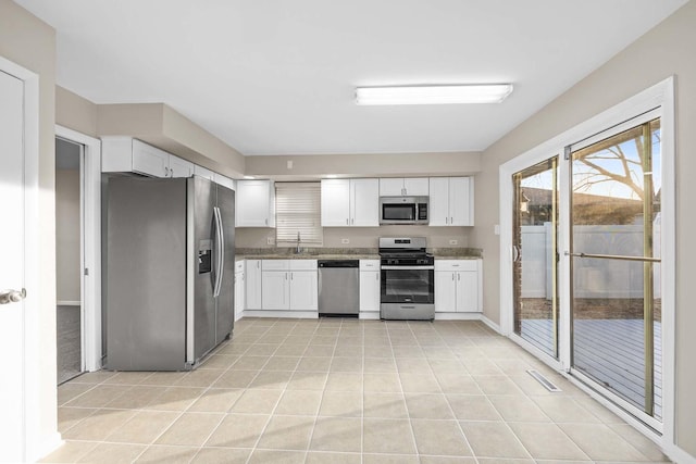 15252 Larkspur Ln, Orland Park, IL 60462 - kitchen with appliances with stainless steel finishes, white cabinets, light tile patterned flooring, stone counters, and baseboards