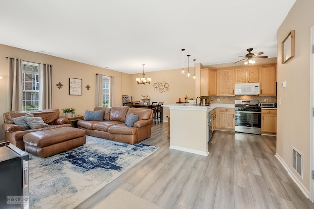 247 Springbrook Trl S, Oswego, IL 60543 - living area featuring light wood-style floors, a chandelier, and a ceiling fan