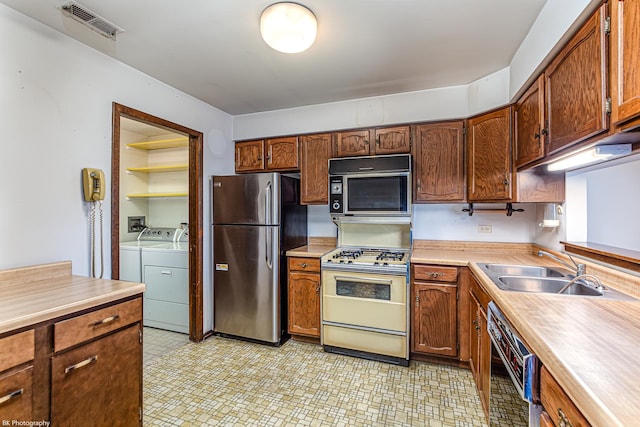8245 Willow Dr Unit 43D, Palos Hills, IL 60465 - kitchen featuring freestanding refrigerator, white range with gas cooktop, washer and dryer, dishwasher, and a sink