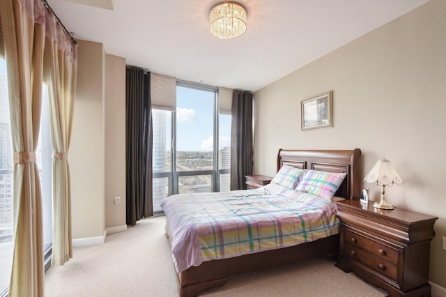 bedroom featuring light colored carpet, baseboards, and a chandelier