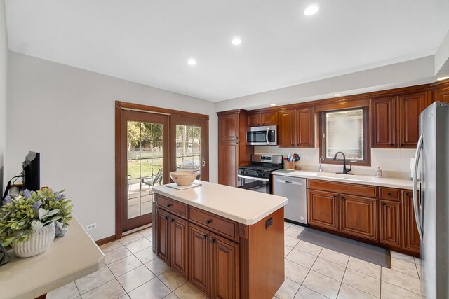 407 Meadow Ave, Frankfort, IL 60423 - kitchen featuring stainless steel appliances, a sink, tasteful backsplash, light tile patterned floors, and light countertops