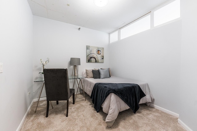 bedroom featuring light carpet and baseboards