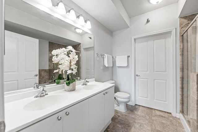 bathroom with a shower stall, toilet, and double vanity