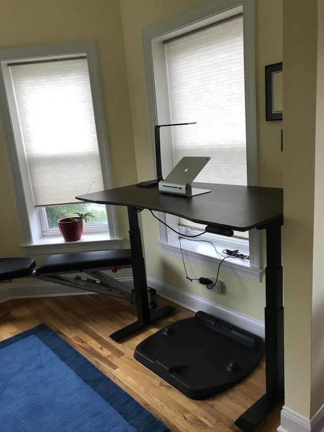 exercise area with wood finished floors and baseboards