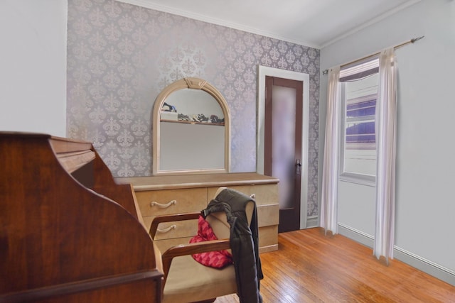 home office with wood finished floors, ornamental molding, and wallpapered walls