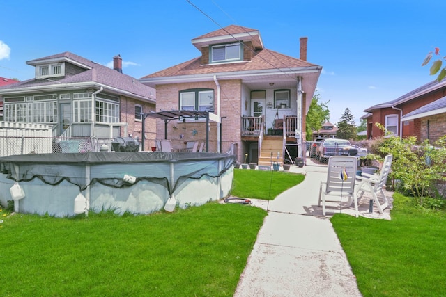 back of property featuring brick siding, a covered pool, a shingled roof, a pergola, and stairs