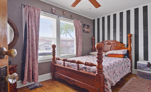 bedroom with wood finished floors, baseboards, a ceiling fan, and crown molding