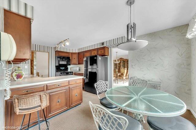 1535 Forest Ave Unit 504, River Forest, IL 60305 - kitchen with black appliances, wallpapered walls, light countertops, brown cabinetry, and a peninsula