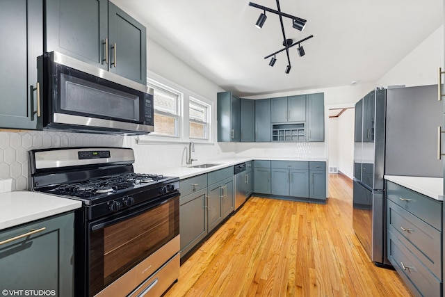 1633 S 18th Ave, Maywood, IL 60153 - kitchen with stainless steel appliances, a sink, light wood-style flooring, tasteful backsplash, and light countertops