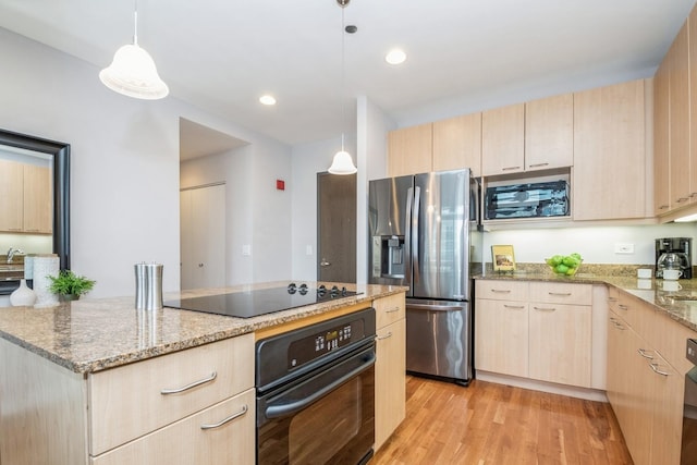 kitchen with black appliances, light brown cabinets, light stone counters, and light wood finished floors