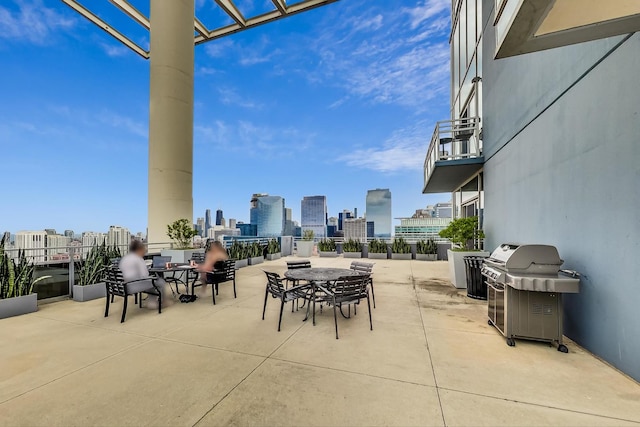 view of patio / terrace featuring a skyline view, grilling area, and a balcony