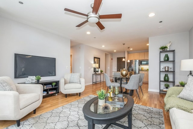 living room with a ceiling fan, light wood-style flooring, recessed lighting, and baseboards