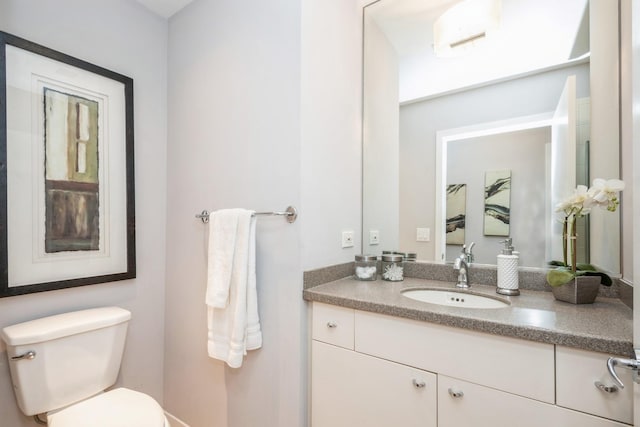 half bathroom featuring toilet and vanity