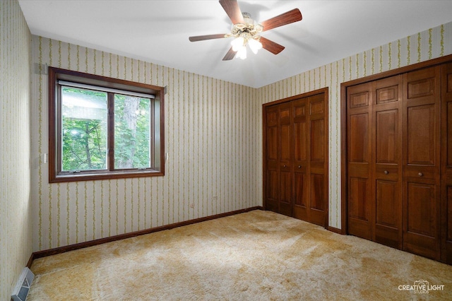 42W325 Jens Jensen Ln, Saint Charles, IL 60175 - unfurnished bedroom with two closets, wallpapered walls, carpet, baseboards, and ceiling fan