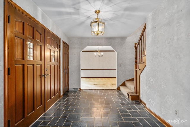42W325 Jens Jensen Ln, Saint Charles, IL 60175 - entryway with a chandelier, stairs, arched walkways, baseboards, and a textured wall