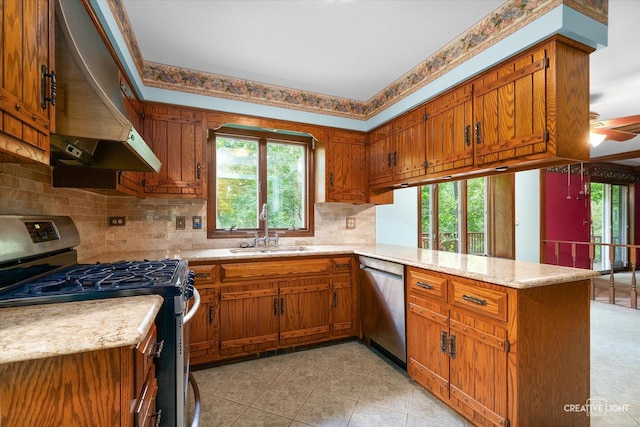 42W325 Jens Jensen Ln, Saint Charles, IL 60175 - kitchen featuring appliances with stainless steel finishes, a sink, exhaust hood, a peninsula, and brown cabinets