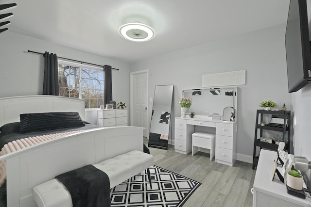 bedroom with light wood-style floors and baseboards