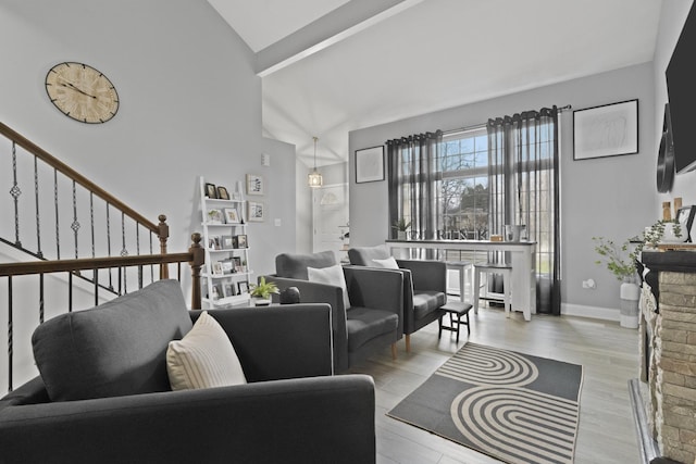living area with wood finished floors, stairway, and high vaulted ceiling