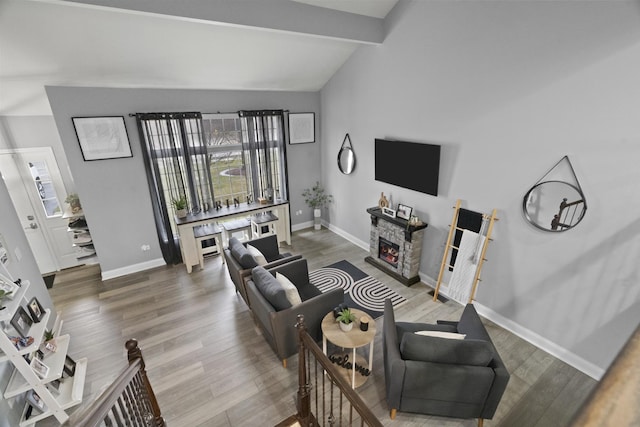 living area with a fireplace, plenty of natural light, and wood finished floors