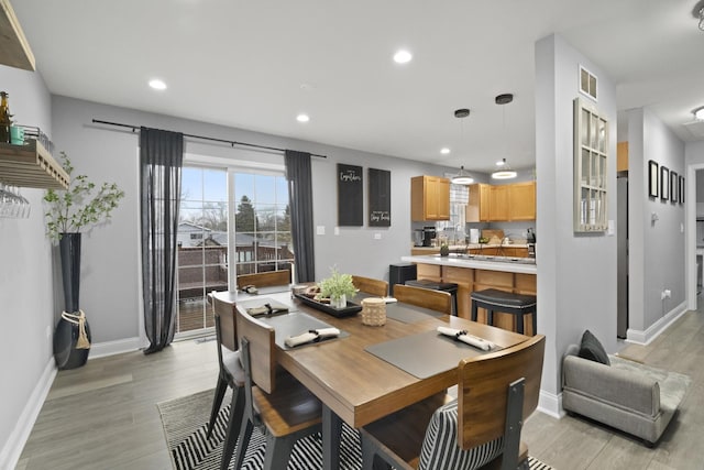 dining area featuring light wood-type flooring, baseboards, and recessed lighting