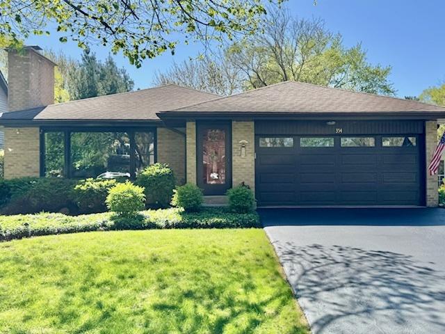 354 Richmond Ln, Lakewood, IL 60014 - ranch-style house featuring a front lawn, an attached garage, asphalt driveway, and brick siding