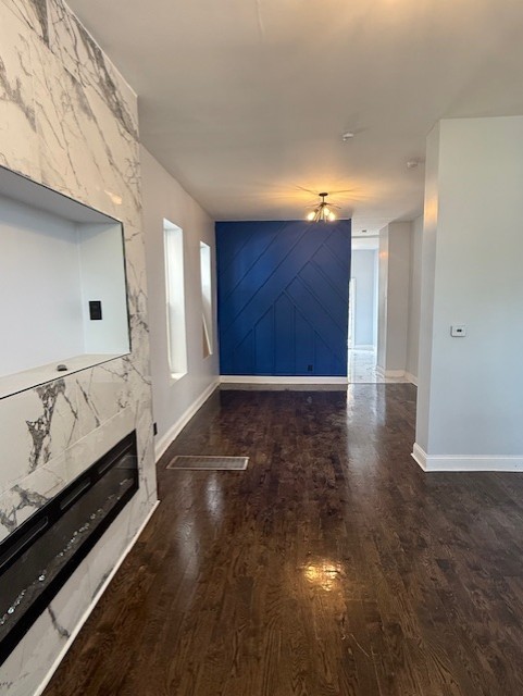 7 W 112th Pl, Chicago, IL 60628 - unfurnished living room featuring wood finished floors, baseboards, and a large fireplace