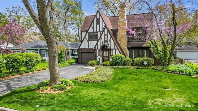 705 Hunter Rd, Glenview, IL 60025 - tudor house with driveway, a front lawn, and an attached garage