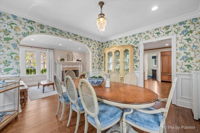 705 Hunter Rd, Glenview, IL 60025 - dining area featuring wallpapered walls, wainscoting, wood finished floors, a fireplace, and crown molding