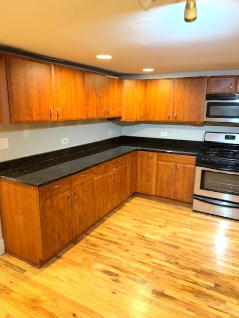 5611 N Glenwood Ave Unit G, Chicago, IL 60660 - kitchen with stainless steel appliances, light wood-style flooring, brown cabinets, and dark stone counters