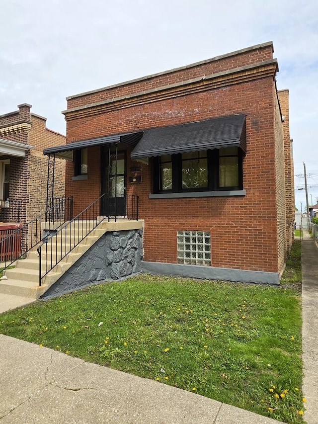 view of front of property featuring brick siding and a front yard