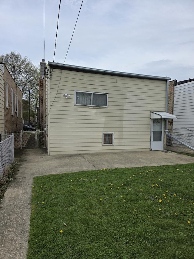 back of house featuring a patio area and a gate