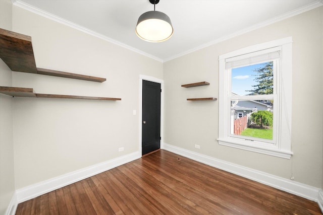spare room with ornamental molding, baseboards, and wood finished floors