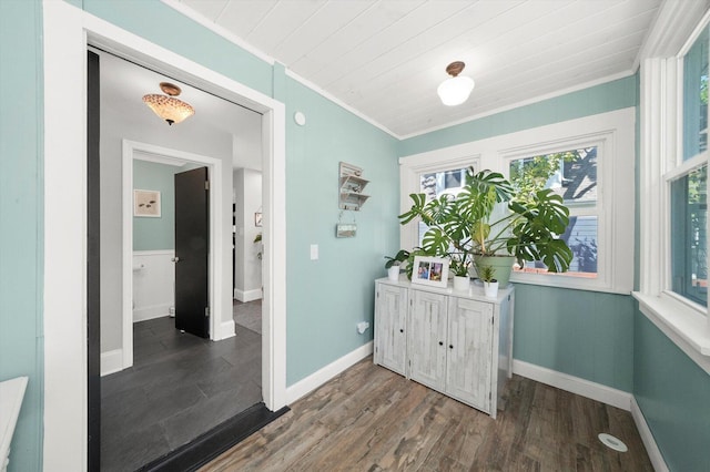 hallway featuring ornamental molding, wood finished floors, and baseboards