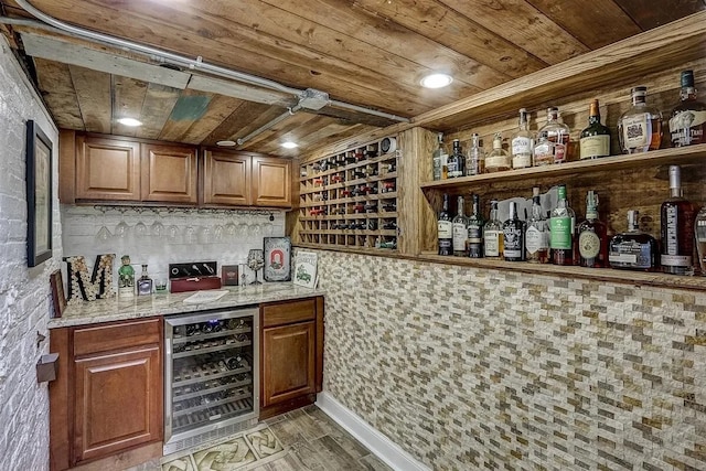 indoor dry bar featuring beverage cooler, wooden ceiling, and light wood finished floors