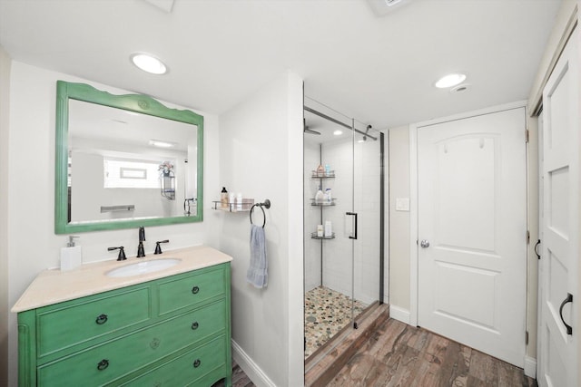 bathroom featuring a shower stall, wood finished floors, vanity, and recessed lighting