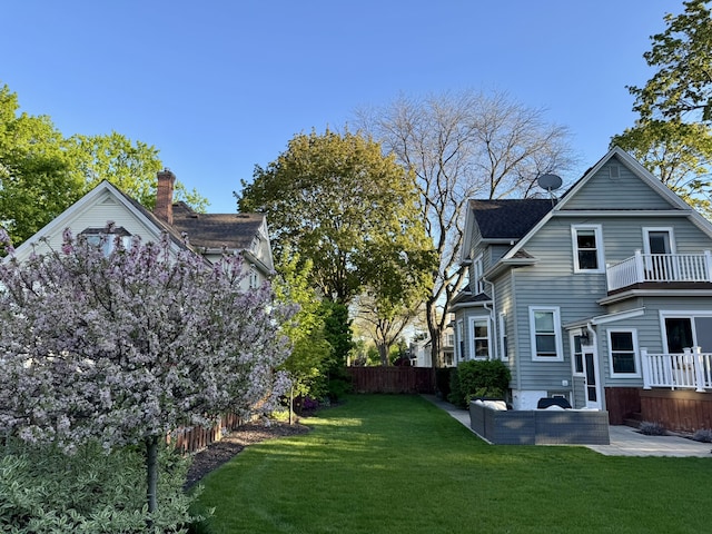 rear view of property featuring outdoor lounge area, a balcony, a patio area, and a chimney