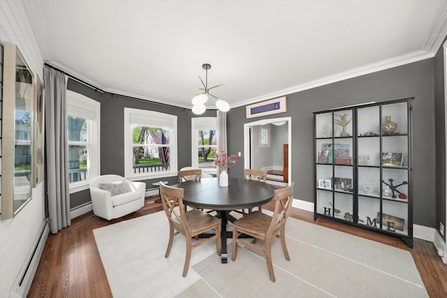 dining area featuring baseboard heating, ornamental molding, wood finished floors, and baseboards