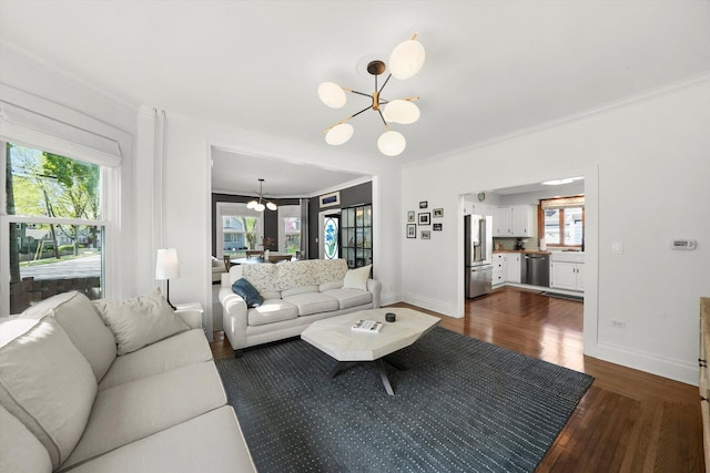 living area with a chandelier, dark wood-style floors, crown molding, and baseboards