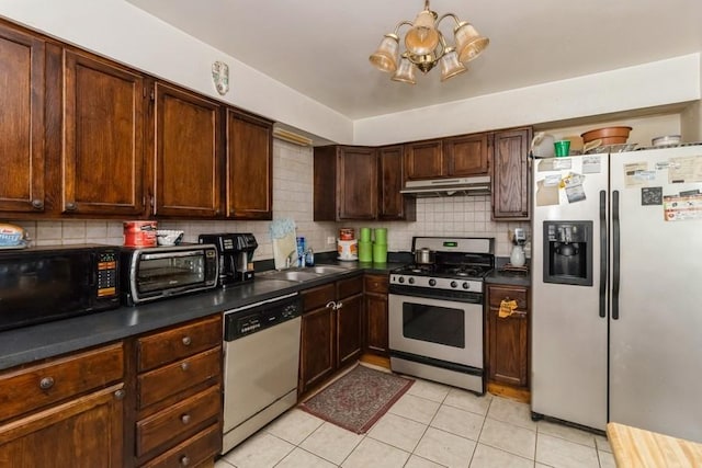 6555 W Addison St Unit A, Chicago, IL 60634 - kitchen with stainless steel appliances, a sink, under cabinet range hood, and tasteful backsplash