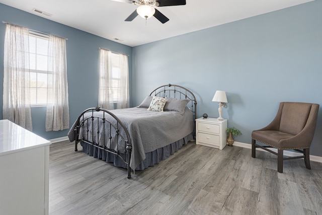 bedroom featuring light wood finished floors, baseboards, and ceiling fan