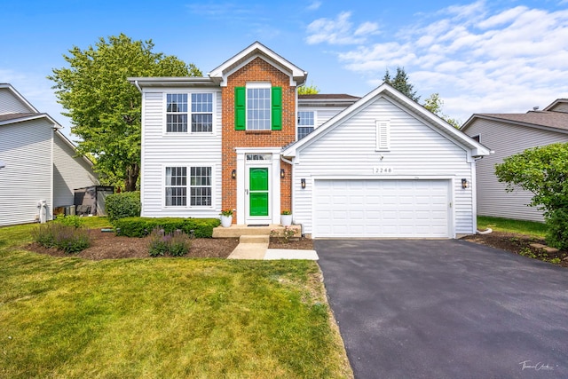 2248 Cheshire Dr, Aurora, IL 60502 - traditional home featuring asphalt driveway, a front lawn, and an attached garage