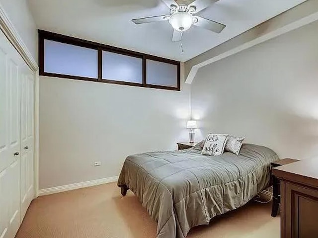 bedroom with light carpet, baseboards, a closet, and ceiling fan