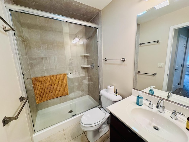 full bath with a shower stall, toilet, vanity, and tile patterned floors
