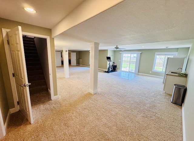 below grade area with light carpet, stairs, baseboards, ceiling fan, and recessed lighting